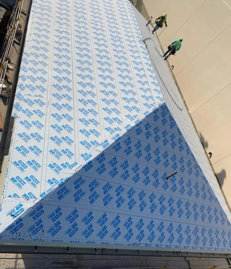 Professional roofers installing underlayment on a metal roof in East Hemet